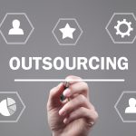 Male hand writing in screen. Outsourcing. The image is trying to depict payroll outsourcing services.